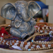 a statue of an elephant sitting on a table with beads