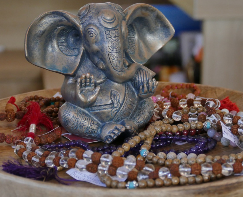 a statue of an elephant sitting on a table with beads